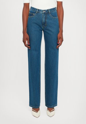 Wide-leg blue denim jeans with a high waist, contrasting stitching, and five-pocket design, finished with a raw hem detail.