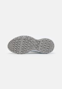 Athletic shoe outsole featuring a textured gray rubber surface with a multidirectional traction pattern and a branded accent.