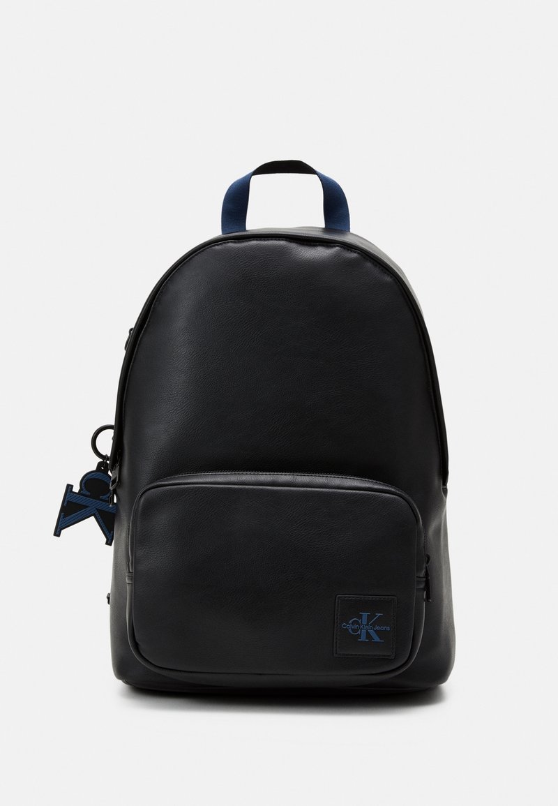 Sac à dos en cuir noir avec une forme arrondie, des accents bleus, une poche zippée à l'avant et une étiquette porte-clés avec un logo bleu.
