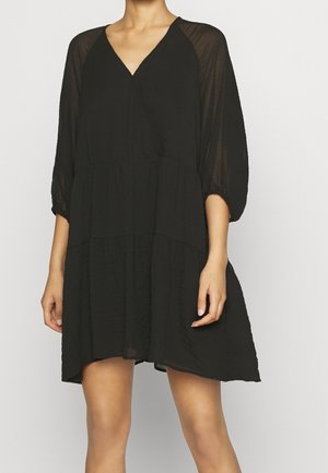 Schwarzes Kleid aus leichtem Stoff, das einen V-Ausschnitt, Dreiviertelärmel und ein gestuftes, fließendes Design mit strukturierter Oberfläche aufweist.