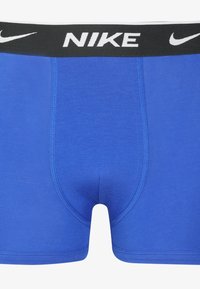 Blauwe katoenen boxershorts met een zwarte tailleband waarop het "NIKE"-logo in het wit staat weergegeven. Gladde textuur en een aansluitend ontwerp met een contourzak.