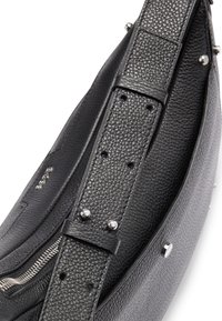 Borsa in pelle nera con finitura texturizzata, caratterizzata da una forma curvata, dettagli in metallo argentato e una tracolla regolabile con cuciture e fori a vista.