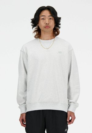 Sudadera de cuello redondo gris con puños y dobladillo acanalados. Presenta un pequeño logotipo sutil en el pecho. Fabricada con material suave y con un ajuste relajado.