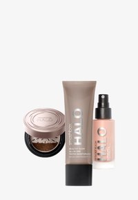 Trois produits Smashbox Halo : un compact rond avec un couvercle en bronze, un tube beige d'hydratant teinté et une bouteille spray transparente avec un embout noir.