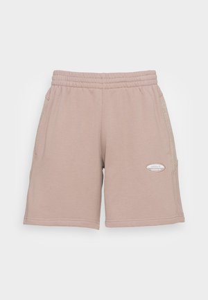 Beige treningshorts laget av mykt stoff, med elastisk livlinning, sidelommer og et lite, tone-i-tone logo-patch.