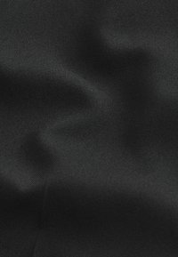 Mustaa kangasta, jossa on sileä, hieman kiiltävä pinta, ominaispiirteenä tasainen kudos ja hillitty kiilto. Ei näkyviä kuvioita tai koristeita.