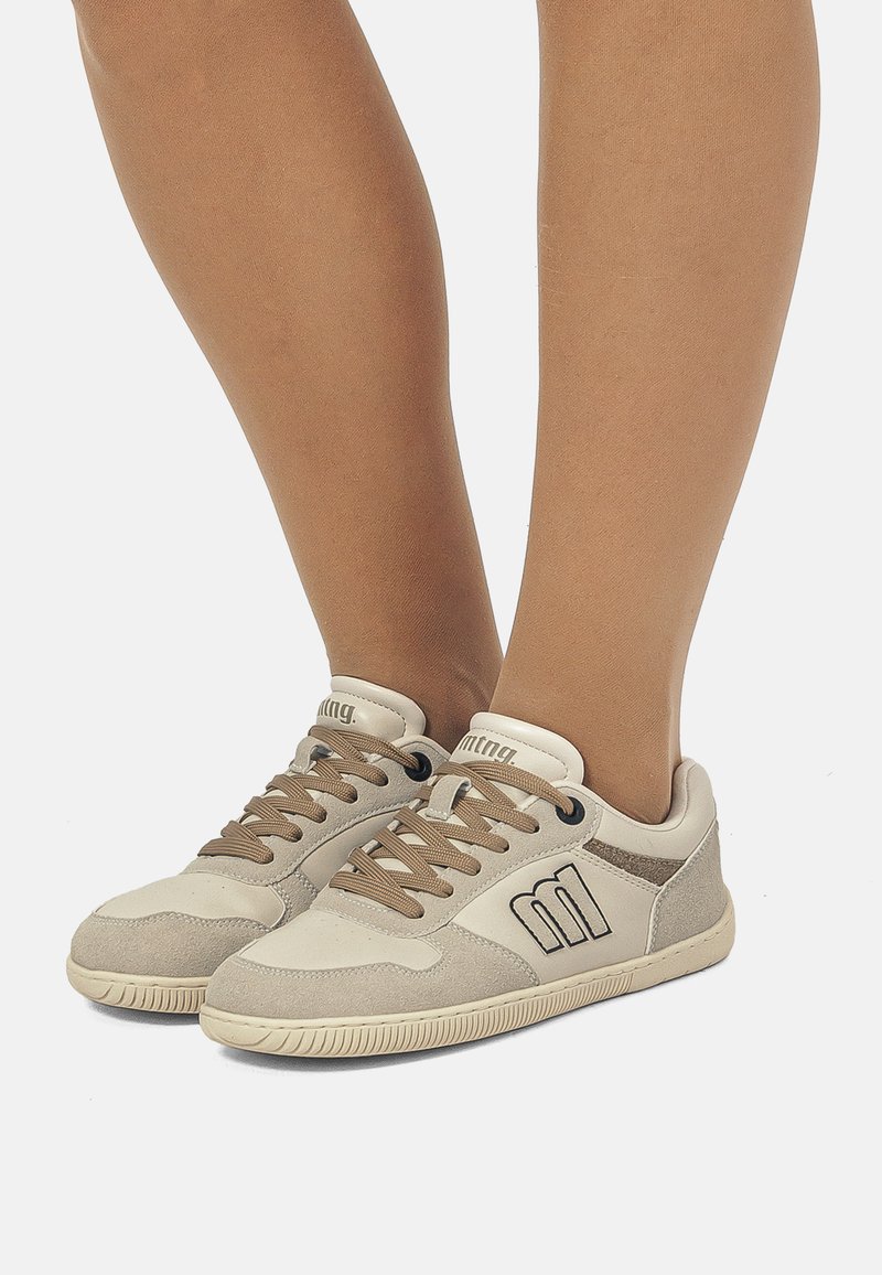 Beige Sneakers mit einem weichen Obermaterial aus Wildleder und Leder, das braune Schnürsenkel, eine strukturierte Sohle und ein Logodetail an der Seite aufweist.