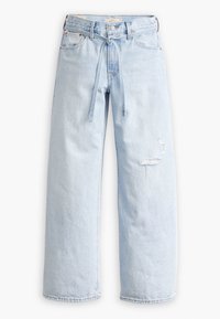 Jeans in denim blu chiaro con taglio a gamba larga, caratterizzati da una vita legata e dettagli strappati sul davanti.