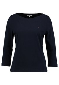 Laivastonsininen pitkähihainen puuvillapaita, jossa on leveä venepääntie ja pieni brodeerattu logo vasemmassa rinnassa. Tasainen pinta.