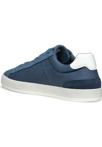 Sneaker blu in tela con un tassello in pelle liscia sul tallone, suola in gomma bianca e lacci tono su tono. Presenta un design elegante e a profilo basso.