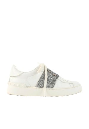 Hvid lav sneakers med tyk sål, sølvglitrende sidestykke, hvide snørebånd og nitter på hælområdet, vist fra siden.