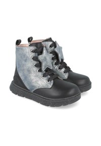 Botas de tobillo negras y plateadas con un material texturizado, adornos en forma de estrella, cordones negros y una suela de goma moteada.