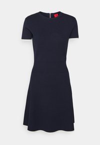 Robe tricotée bleu marine avec des manches courtes, un col rond, un corsage ajusté, une jupe évasée, une taille côtelée et des bordures blanches aux extrémités des manches.