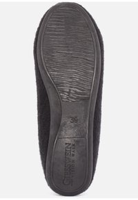 La suola di un ciabattino nero presenta una gomma testurizzata con scanalature per la presa, contrassegnata con "39" e "GESSWEIN VISION WALK," circondata da un materiale morbido e peloso.