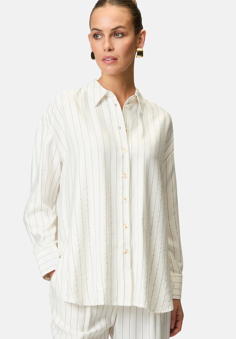 Camicia bianca a bottoni in tessuto leggero, caratterizzata da strisce verticali blu, un colletto a punta e maniche lunghe con dettagli ai polsini.