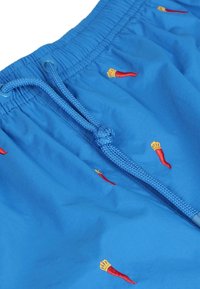 Pantaloni da bagno blu con elastico in vita e cordoncino. Presentano ricami di peperoncini rossi e gialli su tutta la superficie. Tessuto morbido.