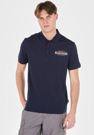 Polo shirt blu navy con colletto bottonato e maniche corte. Presenta un'etichetta con logo sul petto sinistro e una parte posteriore liscia. Materiale in cotone morbido.