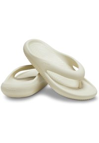 Crème-kleurige flip-flops gemaakt van flexibel materiaal met een gestructureerde voetbed, met een minimalistisch ontwerp en open teen met een kenmerkend logo.