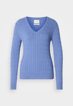 Light blue cable-knit sweater with a V-neck, long sleeves, ribbed hem, and a small logo emblem on the chest. Made from soft fabric.
