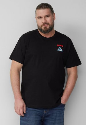 Zwarte katoenen t-shirt met een rood "JAWS" logo en een kleurrijke haai en golf graphic; korte mouwen en ronde halsontwerp.