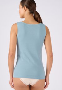 Top all'uncinetto blu senza maniche con scollatura rotonda e design aderente. Tessitura liscia, tessuto leggero e linee pulite.