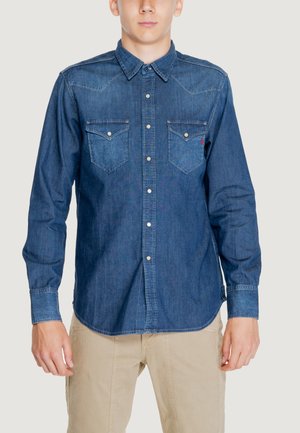 Camicia in denim blu scuro con frontale a bottoni, colletto a punta, due tasche sul petto e dettagli di cucitura in contrasto. Maniche lunghe con polsini a bottoni.