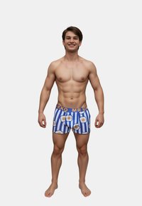 Boxershorts med blå og hvide lodrette striber, der har et mønster af stegte æg. Elastikken er orange med teksten "MR UKKO".