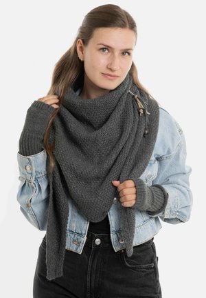 Grijze gebreide sjaal met een textuurpatroon, om de nek gedrapeerd, gecombineerd met een spijkerjack en geribde grijze handschoenen zonder vingers.