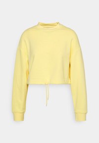 Sweat-shirt court jaune en tissu doux. Comprend des manches longues, un col montant et un cordon de serrage à l'ourlet pour ajuster la coupe.