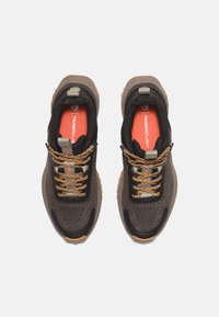 Zapatillas de malla oscuras con acentos en marrón y negro, que cuentan con suelas de goma beige, cordones texturizados y una plantilla naranja con el logo.