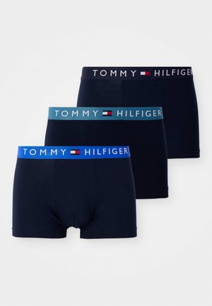 Tres pares de calzoncillos de color navy con cinturillas elásticas; uno con cinturilla azul, otro con cinturilla verde azulado y otro con cinturilla negra con "TOMMY HILFIGER."