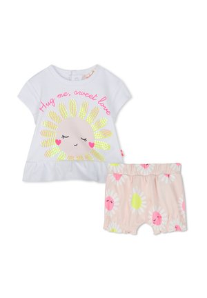 Camiseta blanca de manga corta con un diseño de sol sonriente, pétalos amarillos y texto rosa. Acompañada de pantalones cortos rosas con margaritas de varios colores.