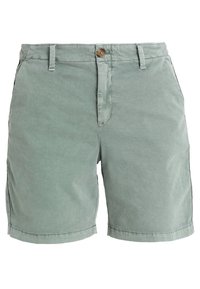 Shorts en coton vert clair avec une fermeture à bouton, des poches avant et des coutures plates. Le matériau a une finition lisse et mate.