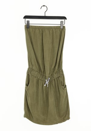 Olivově zelené šaty ke kolenům s elastickým pasem, bočními kapsami a šňůrkovým detailem. Měkká textura a uvolněný střih.