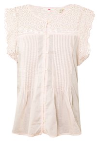 Blouse rose clair avec un devant texturé, des manches courtes en dentelle et un design à boutons. Présente des plis froncés à la taille.