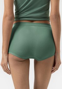 Vihreät, saumatonta poikapöksyt, jotka on valmistettu pehmeästä, joustavasta materiaalista. Niissä on matala vyötärö ja sileä vyötärönauha sekä teksturoitu pinta.