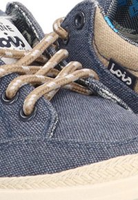 Zapato casual de tela azul con cordones de patrón beige y blanco, ribete beige y etiqueta con el logo "Lois" en el lateral.
