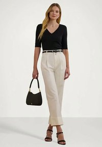 Juodas trumpas rankovėmis V formos iškirpėles viršus, grietinėlės spalvos aukšto juosmens kelnės su raukšlėmis, juoda rankinė ir juodos juostelės šlepetės. Paprastas, pritaikytas dizainas.