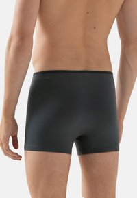 Svarta boxershorts med rutmönster, tillverkade av mjukt tyg. Har en låg midja och kort benlängd, utformade för komfort och passform.