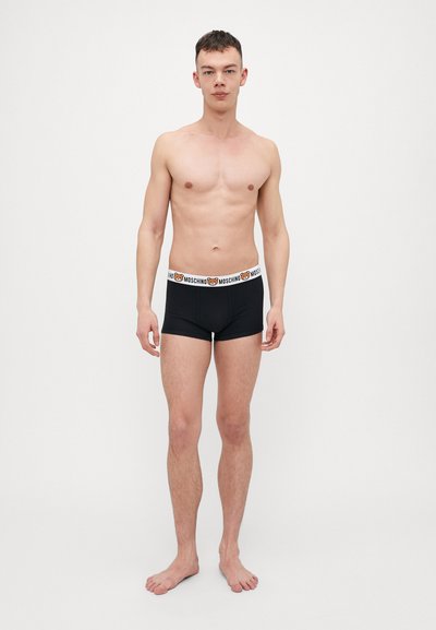 Bóxer negro para hombre con una cintura blanca que presenta un logo de oso, fabricado en tejido suave, ajuste ceñido y diseño minimalista.