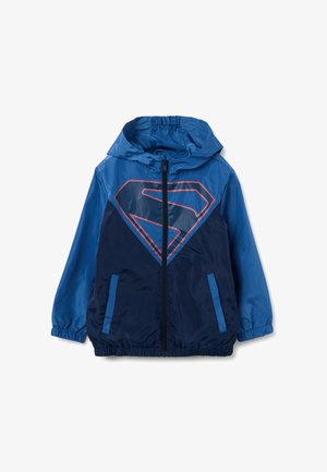 Blauwe zip-up jas met een capuchon, voorzien van een groot rood en marineblauw Superman-logo op de voorkant, elastische manchet en zijzakken.