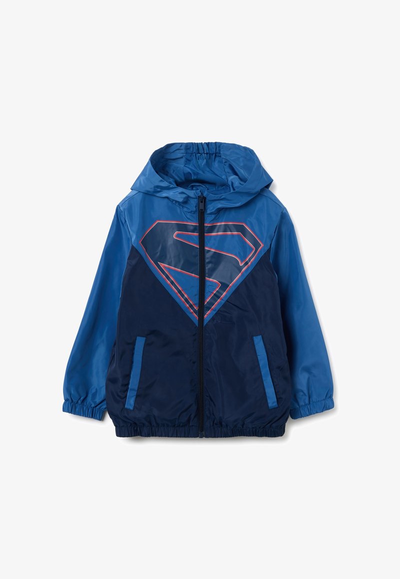 Blaue Zip-Jacke mit Kapuze, featuring ein großes rotes und navy Blau Superman-Logo auf der Vorderseite, elastische Bündchen und Seitentaschen.