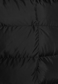 Czarna kurtka puchowa z gładkim, błyszczącym materiałem i przeszywanymi panelami. Powierzchnia ma jednolity kolor i subtelny połysk.