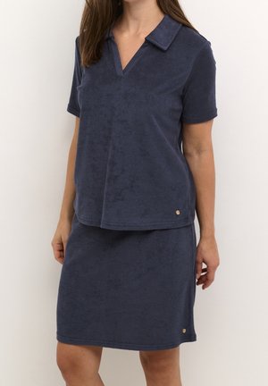 Marineblå tofars-outfit lavet af blødt frotté stof, der har en kortærmet skjorte med krave og en knælængde nederdel med metaldetaljer.