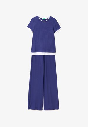 Blauw topje met korte mouwen en witte biezen aan mouwen en zoom, gecombineerd met bijpassende wijde pijpen broek.