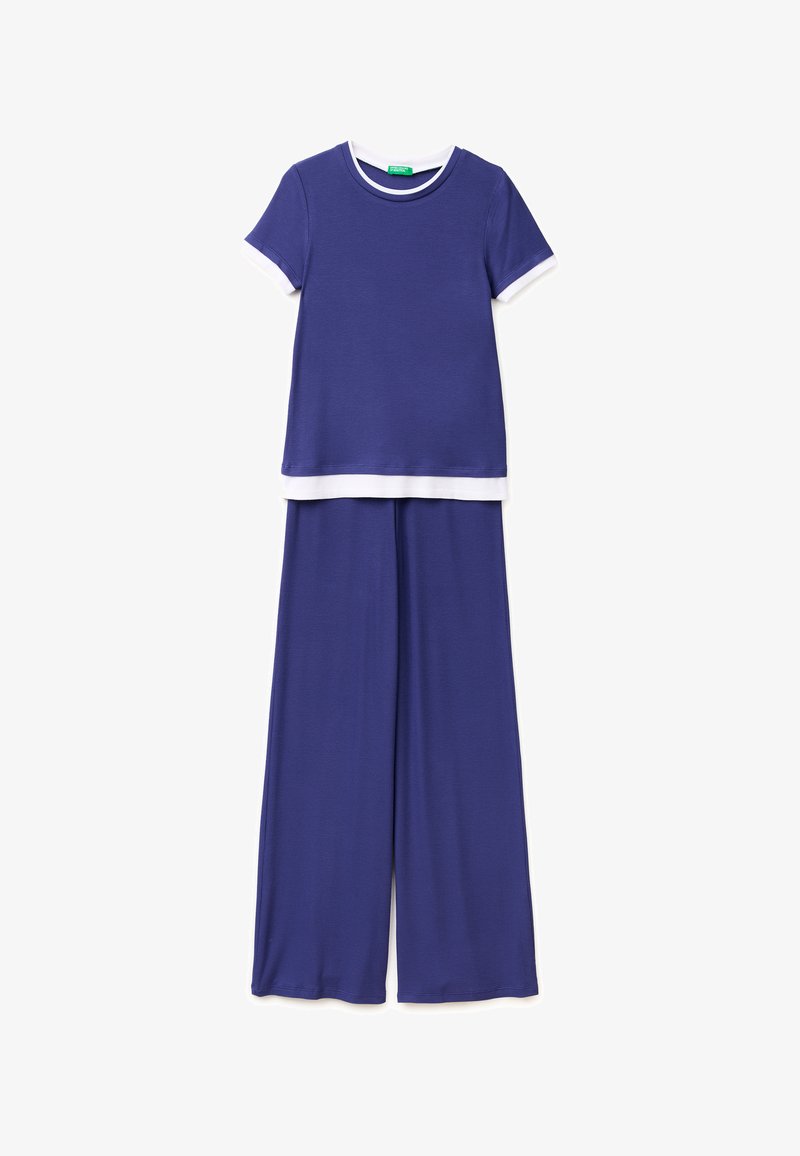 Niebieska bluzka z krótkim rękawem z białym wykończeniem na rękawach i na dole w połączeniu z pasującymi szerokimi spodniami.