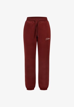 Pantaloni sportivi bordeaux in tessuto morbido con vita elastica e cordino. Presentano polsini affusolati e un logo ricamato bianco sul lato.