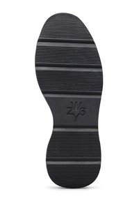 Suola di scarpe nera con scanalature orizzontali e un logo "W6YZ" in rilievo al centro, mostrata su uno sfondo bianco.