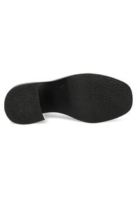 Suela de zapato de goma negra con superficie texturada y un ligero tacón, que presenta un borde curvado y una zona plana y lisa en el talón.