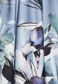 Blumenstoff in Blau-, Grün- und Schwarztönen mit großen Lilienmotiven, glatter Textur und subtilem Aquarelleffekt.